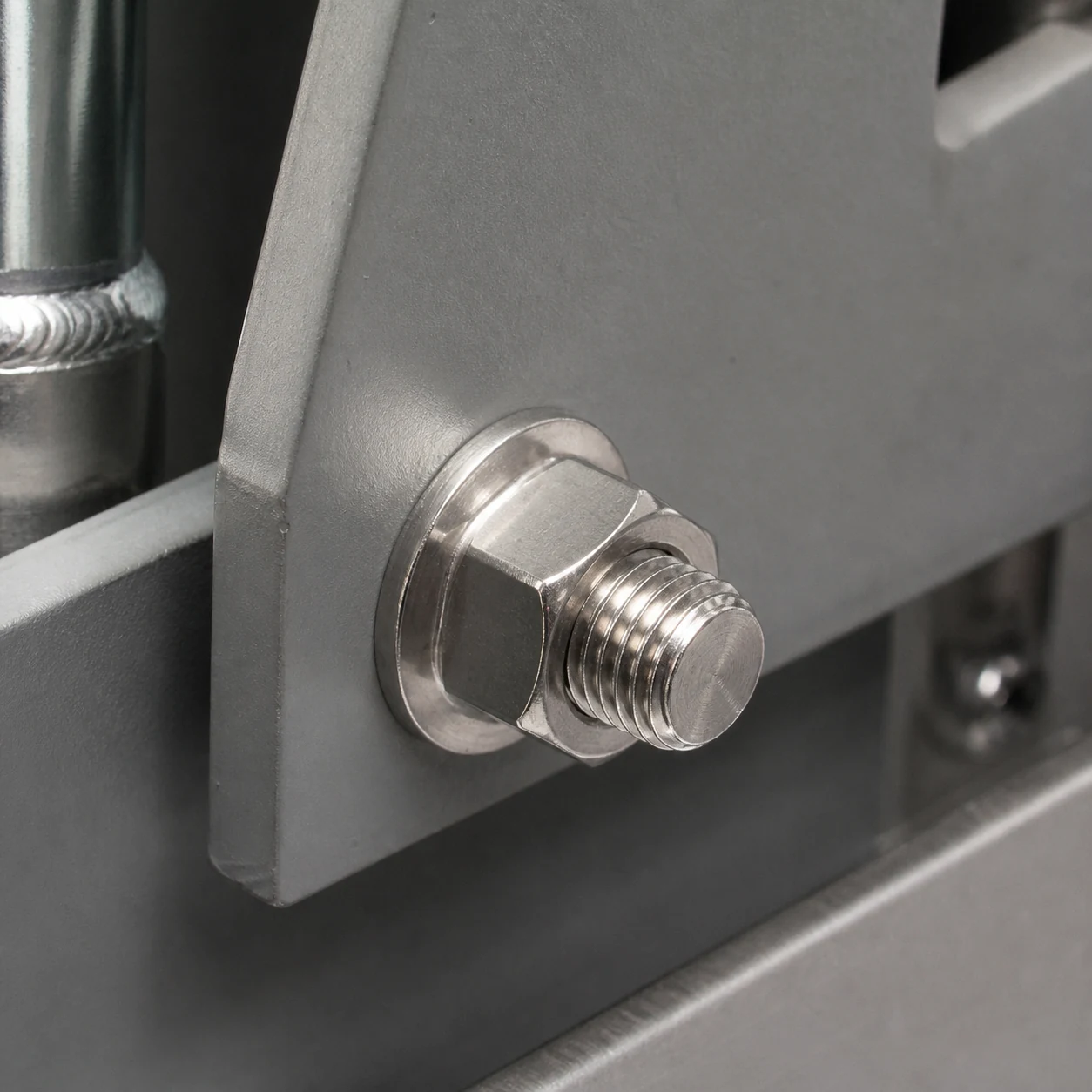 Stainless steel flange nut installed directly on an industrial machinery bracket with a matching bolt