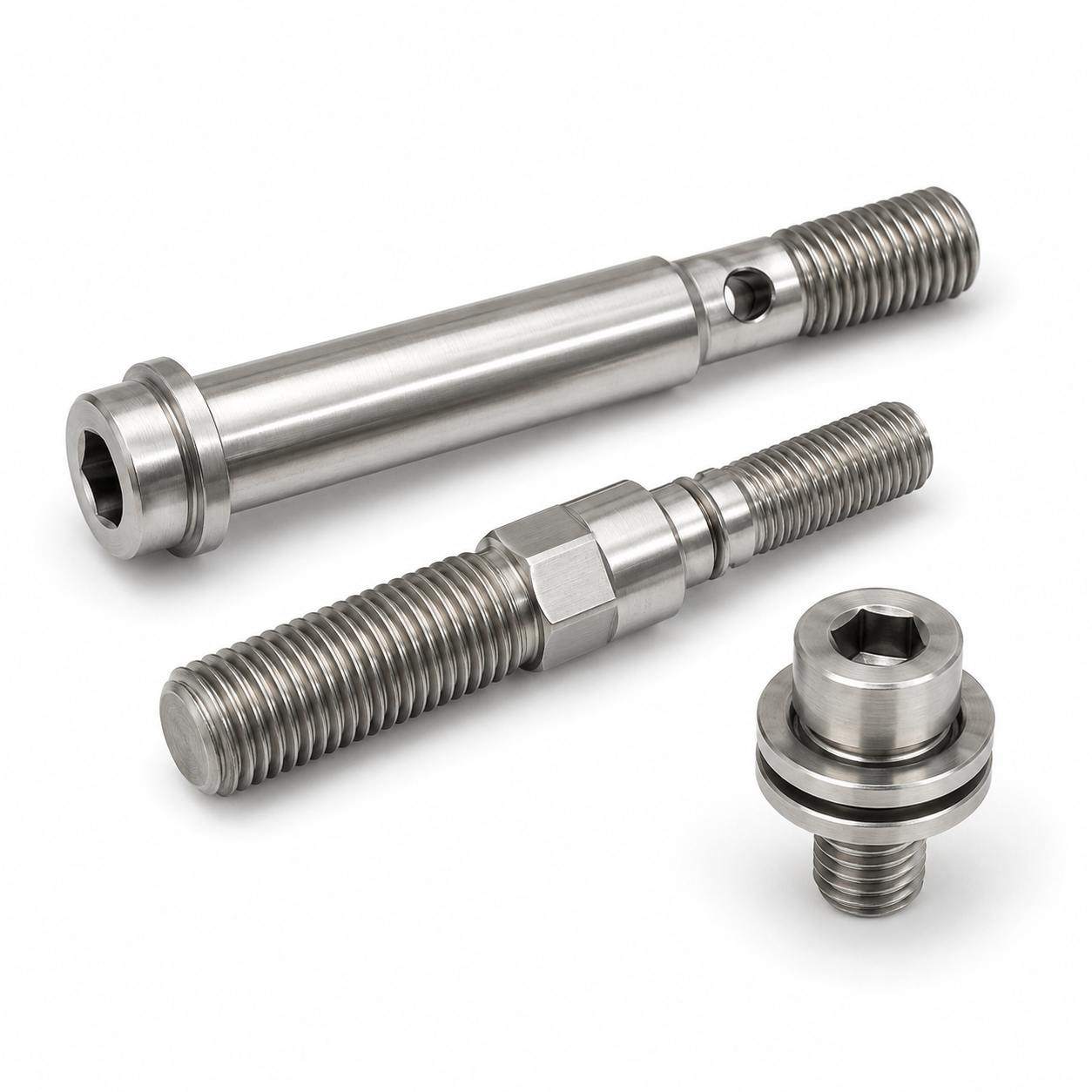 Three precision-machined non-standard stainless steel fasteners with custom shoulder, thread and captive geometry